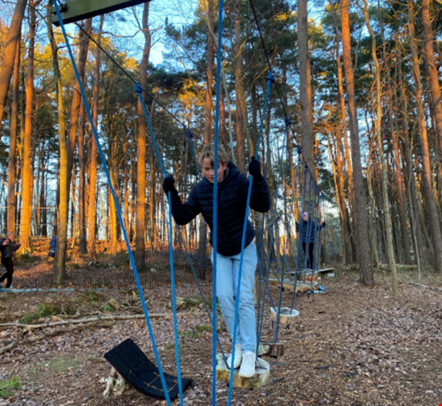 Pojke klättrar på låghöjdsbanan. 