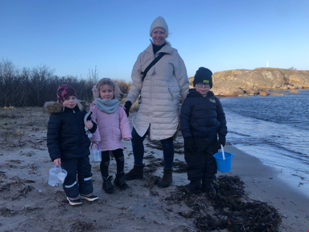 Vuxen och barn på en vintrig strand.