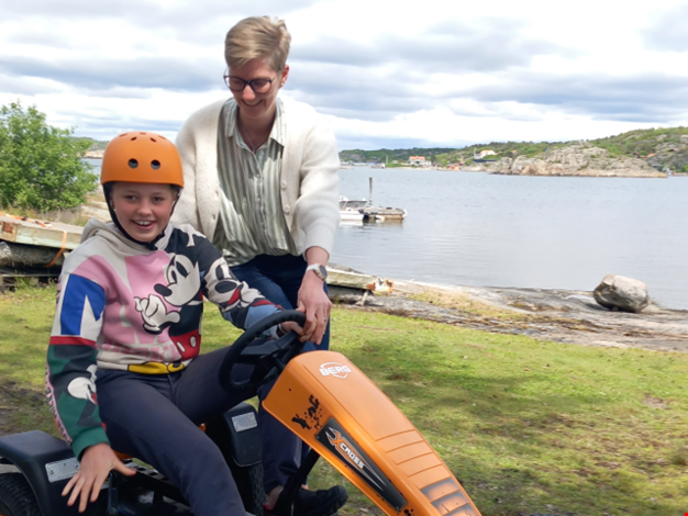 Lisa åker trampbil med hjälp av sin mamma Karin.