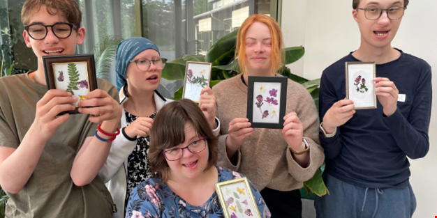 En grupp ungdomar visar upp sina blomstertavlor.