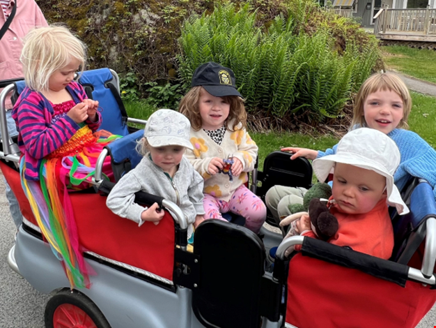 Fem barn sitter i kompisbussen. 