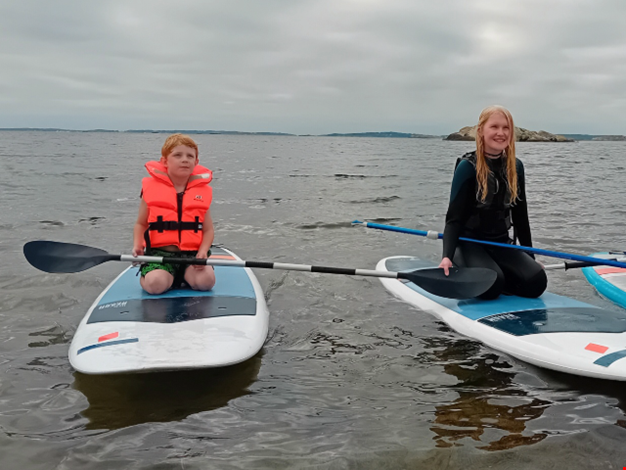 Två barn åker SUP.