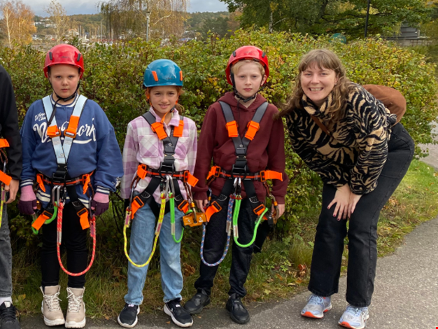 En grupp barn i selar redo för zipline.
