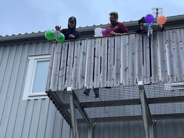 Barn och vuxen står uppe på en balkong.