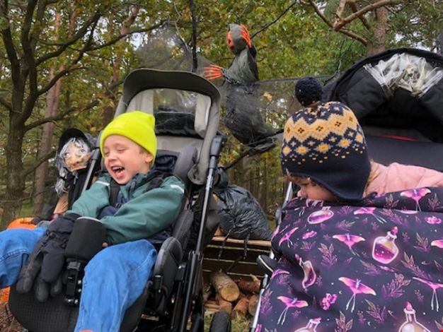Barn i vagn ute i skogen.