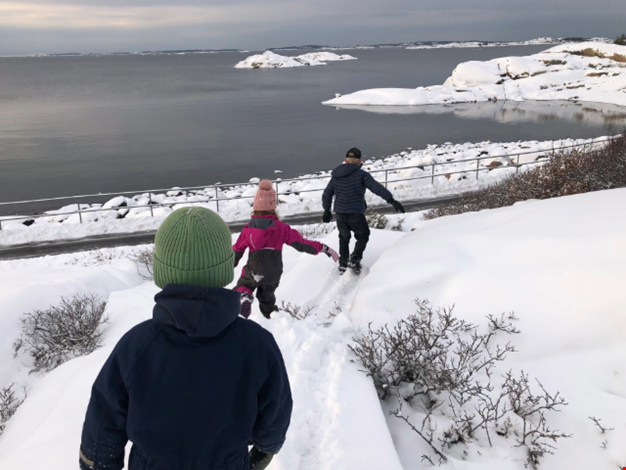 Barn vid havet i vinterlandskap.