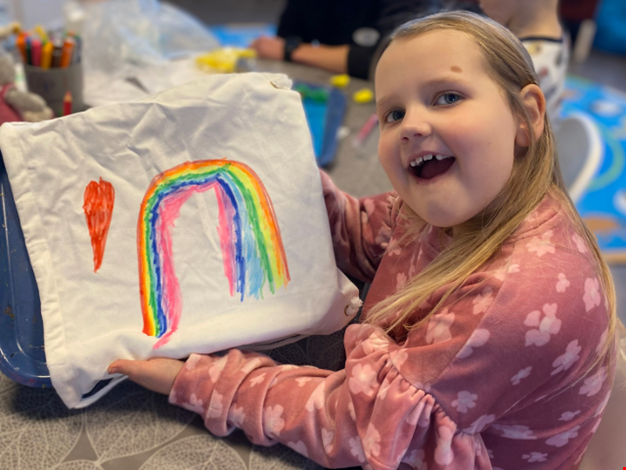 Flicka som visar upp sin målning.