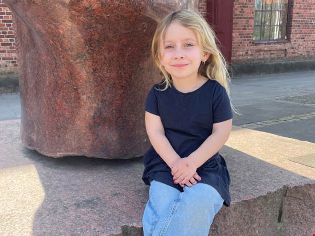 Flicka som sitter med benen i kors.