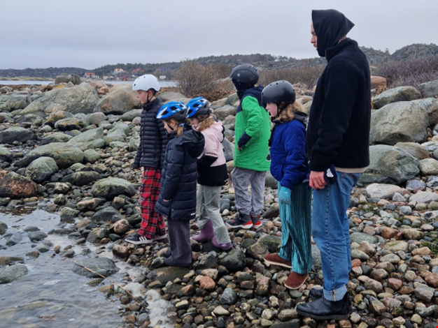Flera barn på en stenstrand.