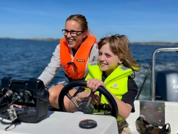 Barn och vuxen åker båt.