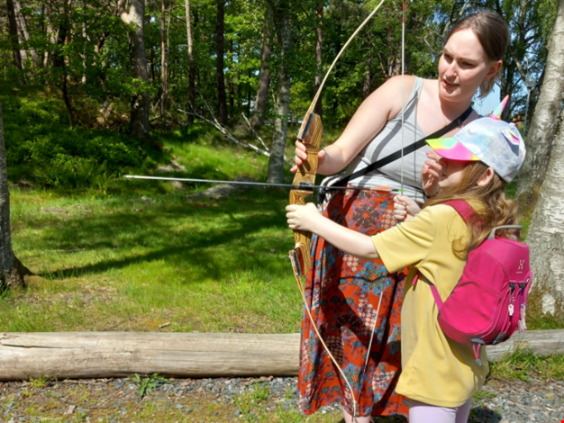 Barn övar på att skjuta med pilbåge.