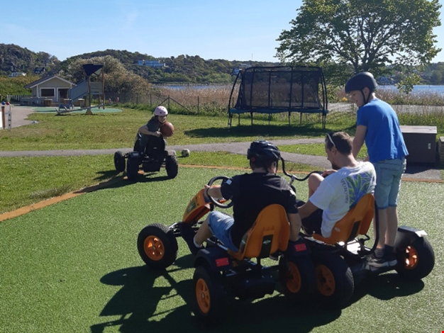 Flera barn åker trampbil.