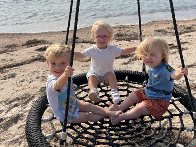 Barn som gungar på stranden. 