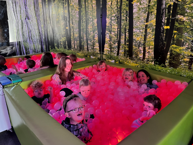 Glada barn myser i bollhavet.