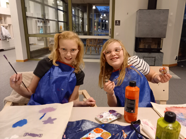 Två kompisar pysslar i stenhuset.