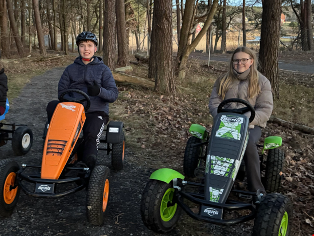 Två pojkar åker trampbil.