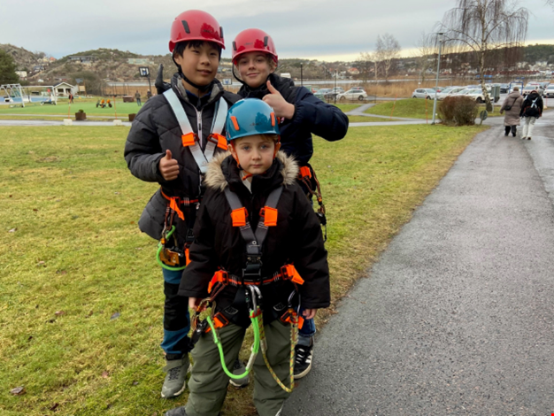 Tre barn i sele redo för zipline.