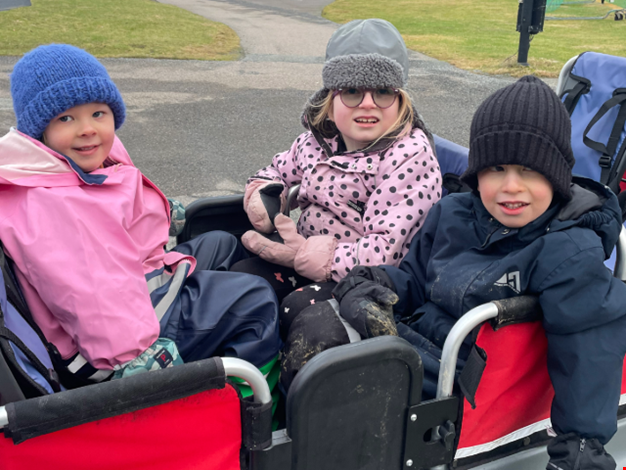 Tre barn åker i kompisbussen.