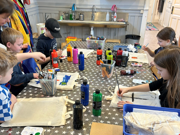 Barn som sitter vid ett bord och pysslar. 