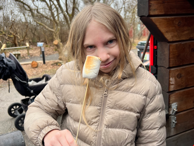 Flicka som grillar marshmallows.