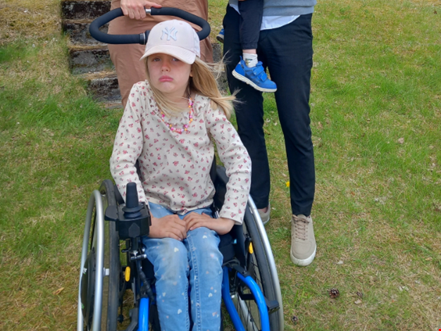 Olivia sitter i sin rullstol