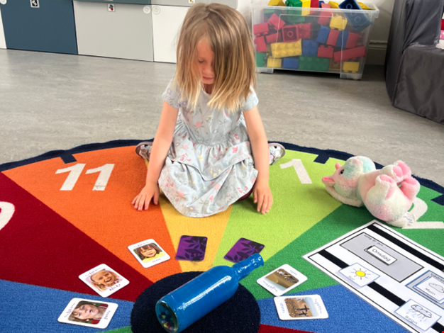 Flicka som leker snurra flaskan.