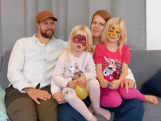 Pappa Samuel, mamma Johanna, Liv och Vilja sitter i en soffa.