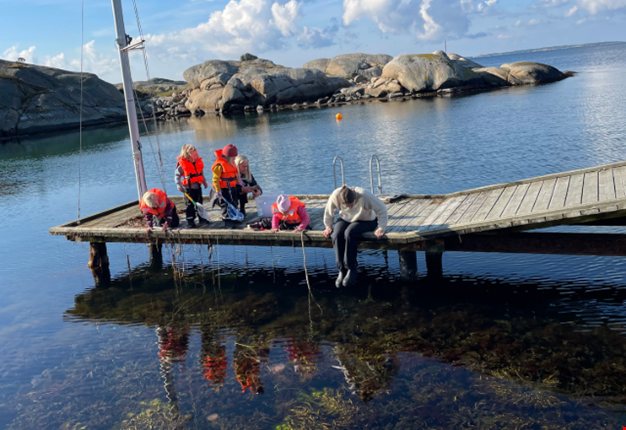 Barn fiskar krabbor på brygga vid havet. 