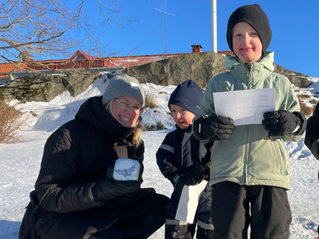 Vuxen och barn som är ute i snön.