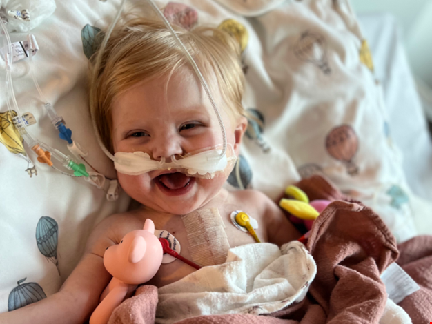 Liv ligger med slangar in i näsan och ler.