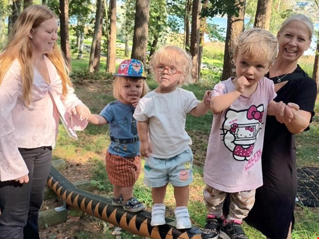 Barn som balanserar i skogen.