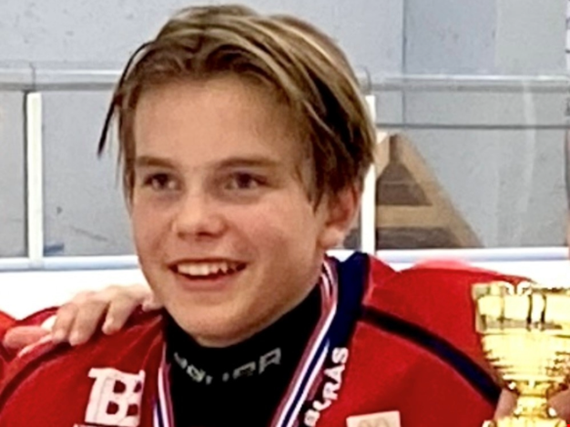 Pojke iklädd hockeyutrustning. 