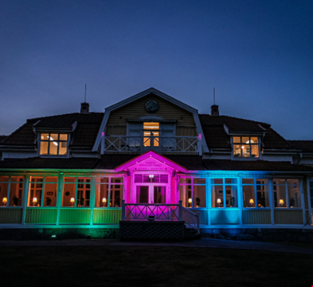 Gula huset på Ågrenska lyses upp med sällsynta färger, grön, rosa och blå.