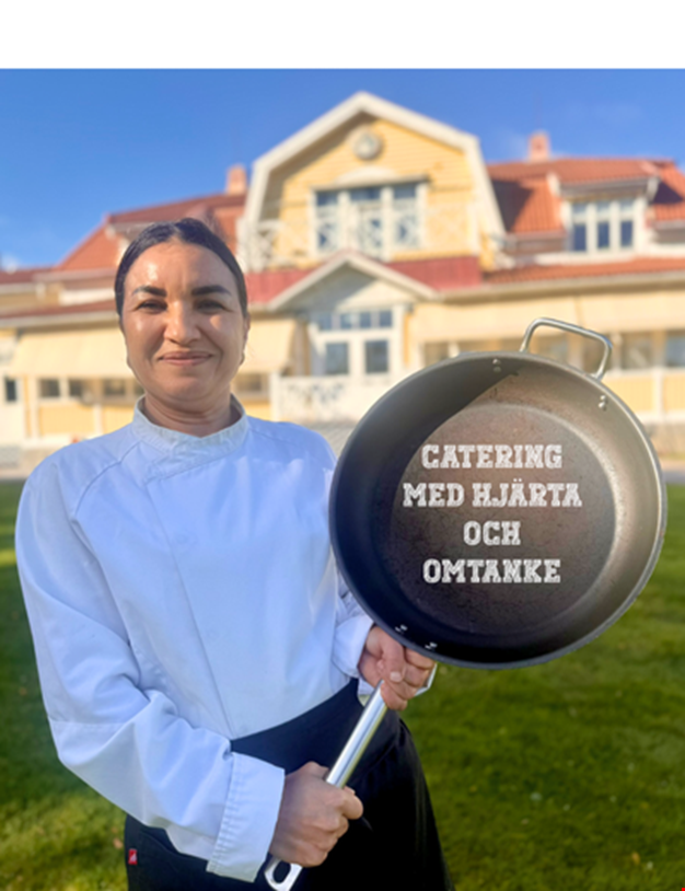 Bild på kökspersonal som står framför gula huset. Personen håller i en stekpanna med texten "catering med kvalitet och omsorg".